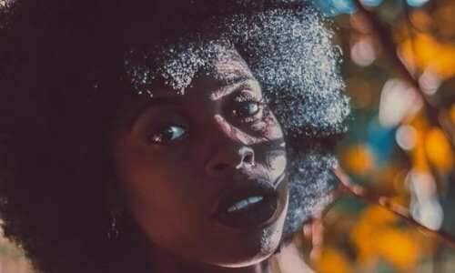 Dry scalp: Close up of a Black woman standing autumnal trees