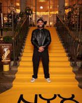 Person standing on a yellow carpet in an elegant interior setting