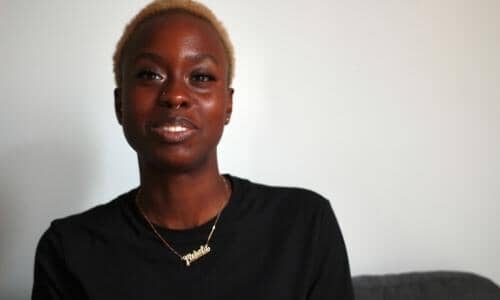 black woman wearing black with short blonde afro