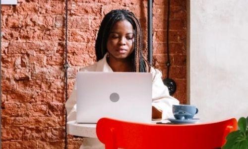 Professional Hairstyles for Black Women: woman with braids working on a laptop