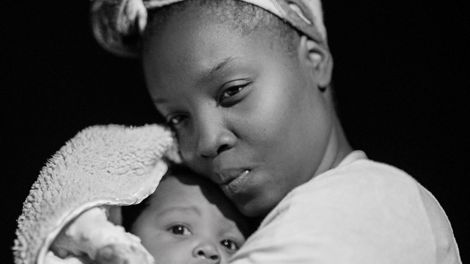 Afrocenchix postpartum hair loss black and white image of woman holding a baby
