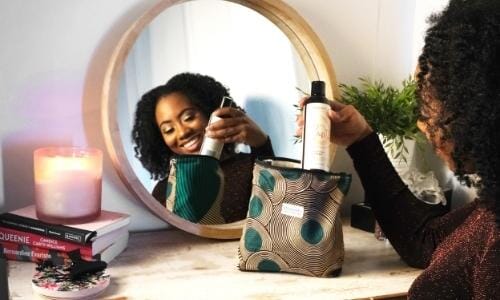How to celebrate Valentine's Day in lockdown featured image: afro-haired woman taking out Afrocenchix product out of African print bag