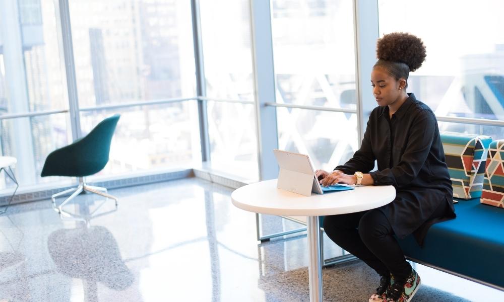 Black woman at a table with laptop