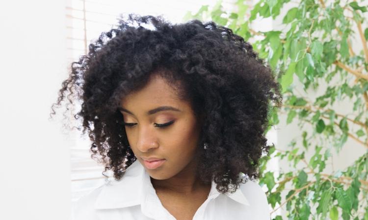 Afro hair breakage: woman with afro hair looking down
