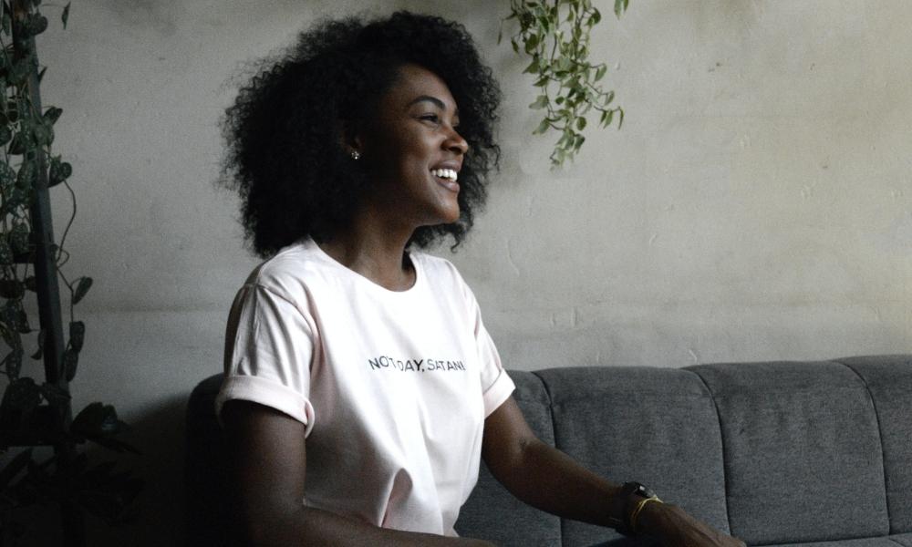 Young black woman with natural hair smiling and laughing 