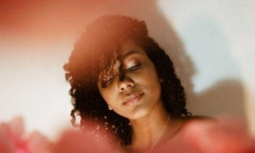 scalp care: black woman with hair tossed looking down