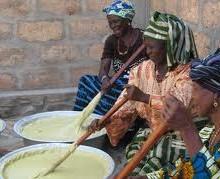 Why We Use Fairtrade, Organic Shea Butter: African women wearing printed clothes stirring shea butter