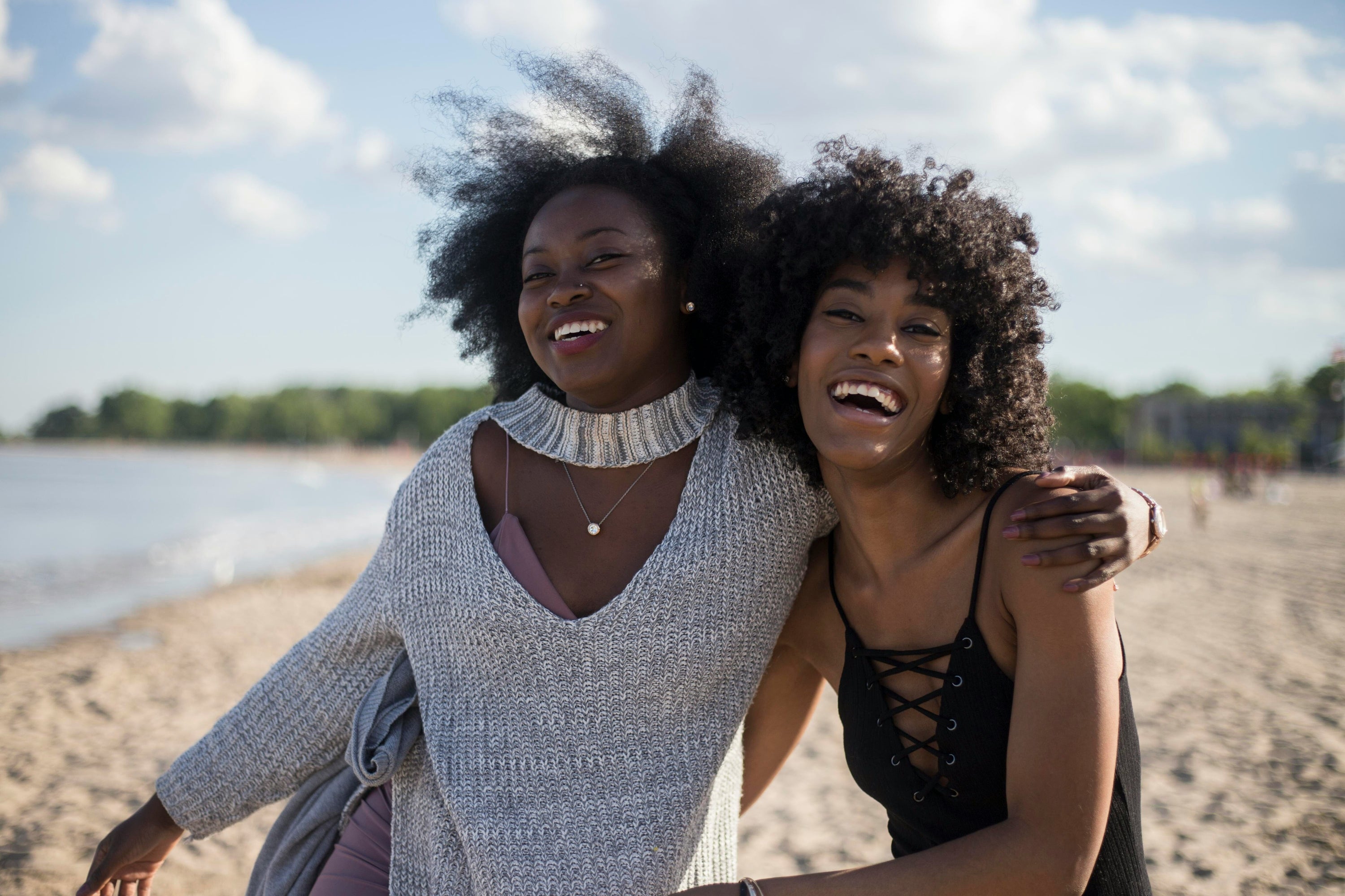 Black woman with sunglasses and hands behind her head. Afrocenchix blog: Summer Hair Care - 8 Tips On How To Keep Your Hair Looking Great