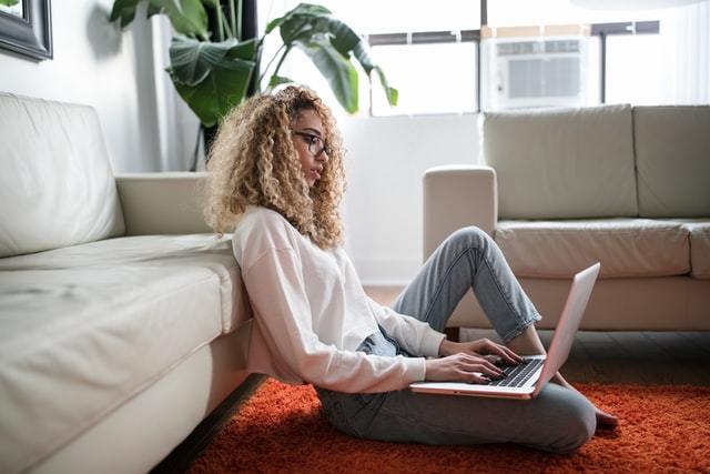 Woman sitting in her living room working on her laptop